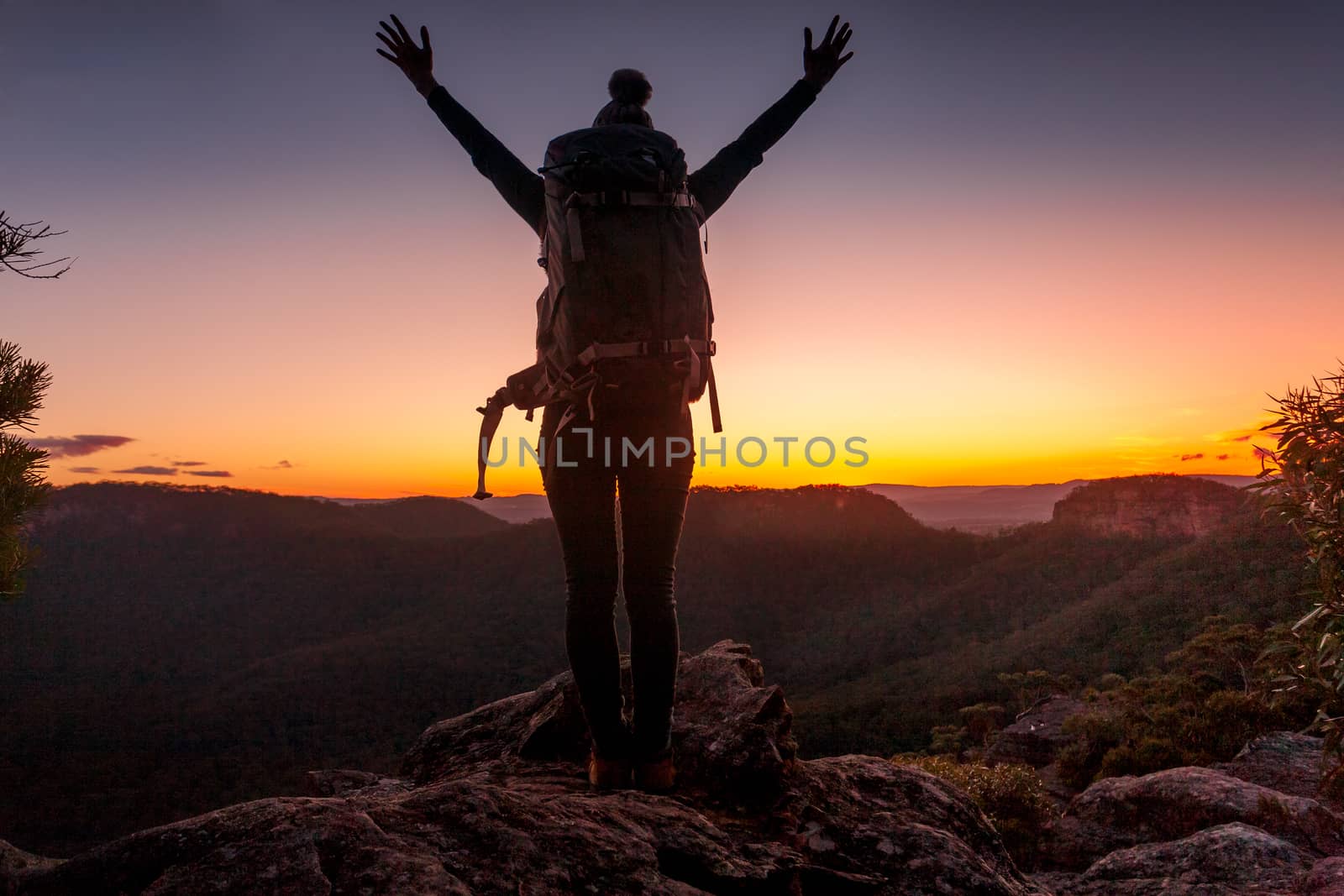 Woman standing on peak, arms raised above head,  that mountain feeling by lovleah