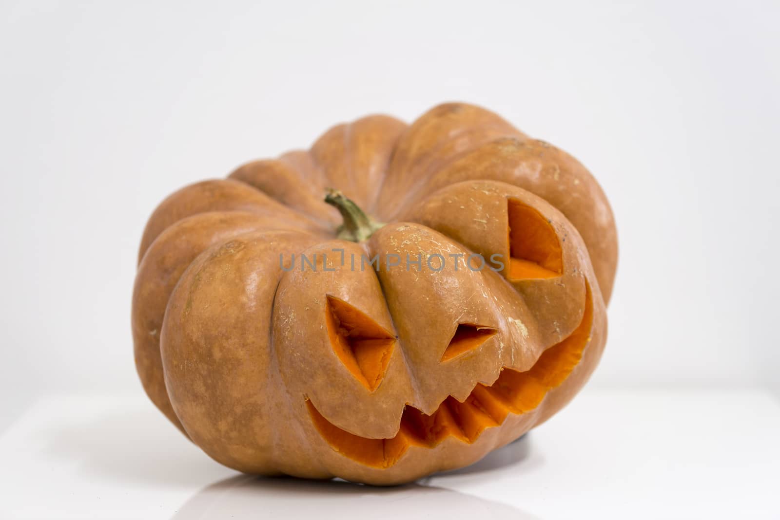 orange halloween pumpkin with carving, crushed and collapsible typology, on a background in nature or white