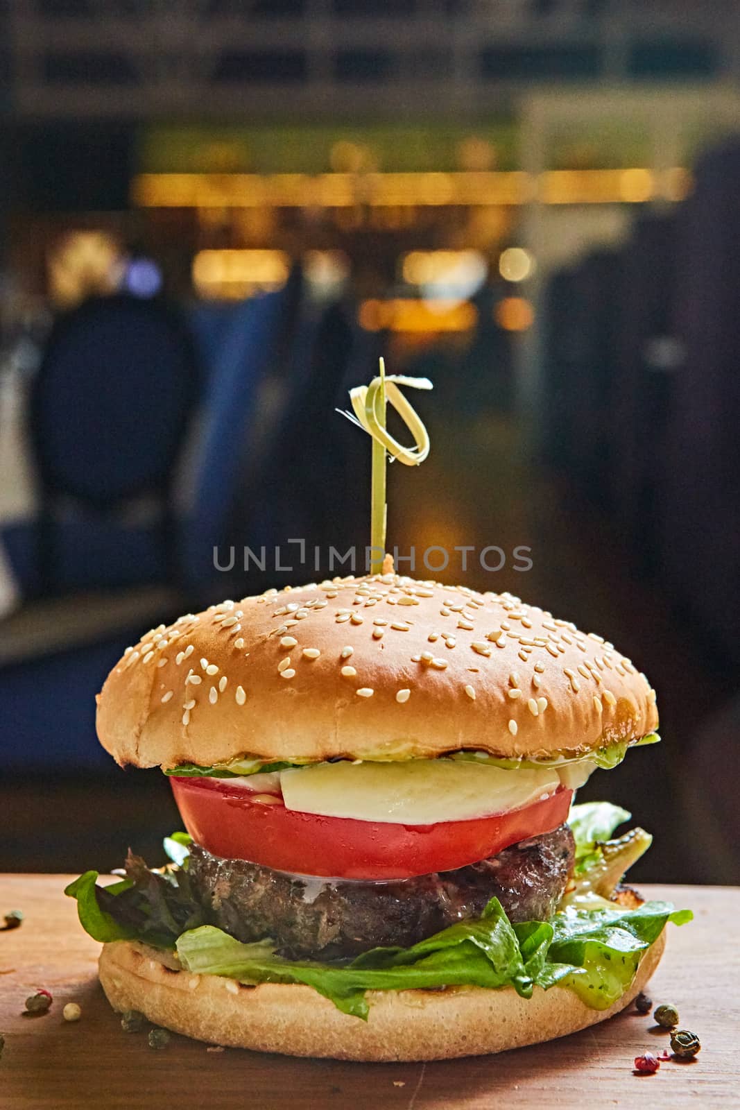 Beef burger with lettuce and mayonnaise served on a rustic wooden table of counter, with copy space. by sarymsakov