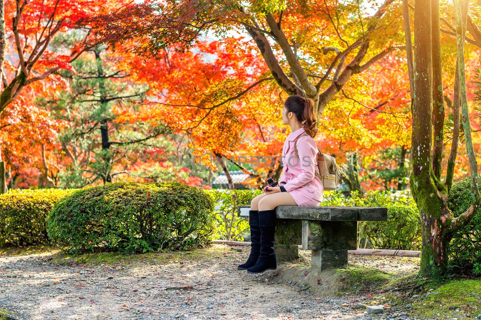 Girl sitting in autumn park, kyoto in Japan.