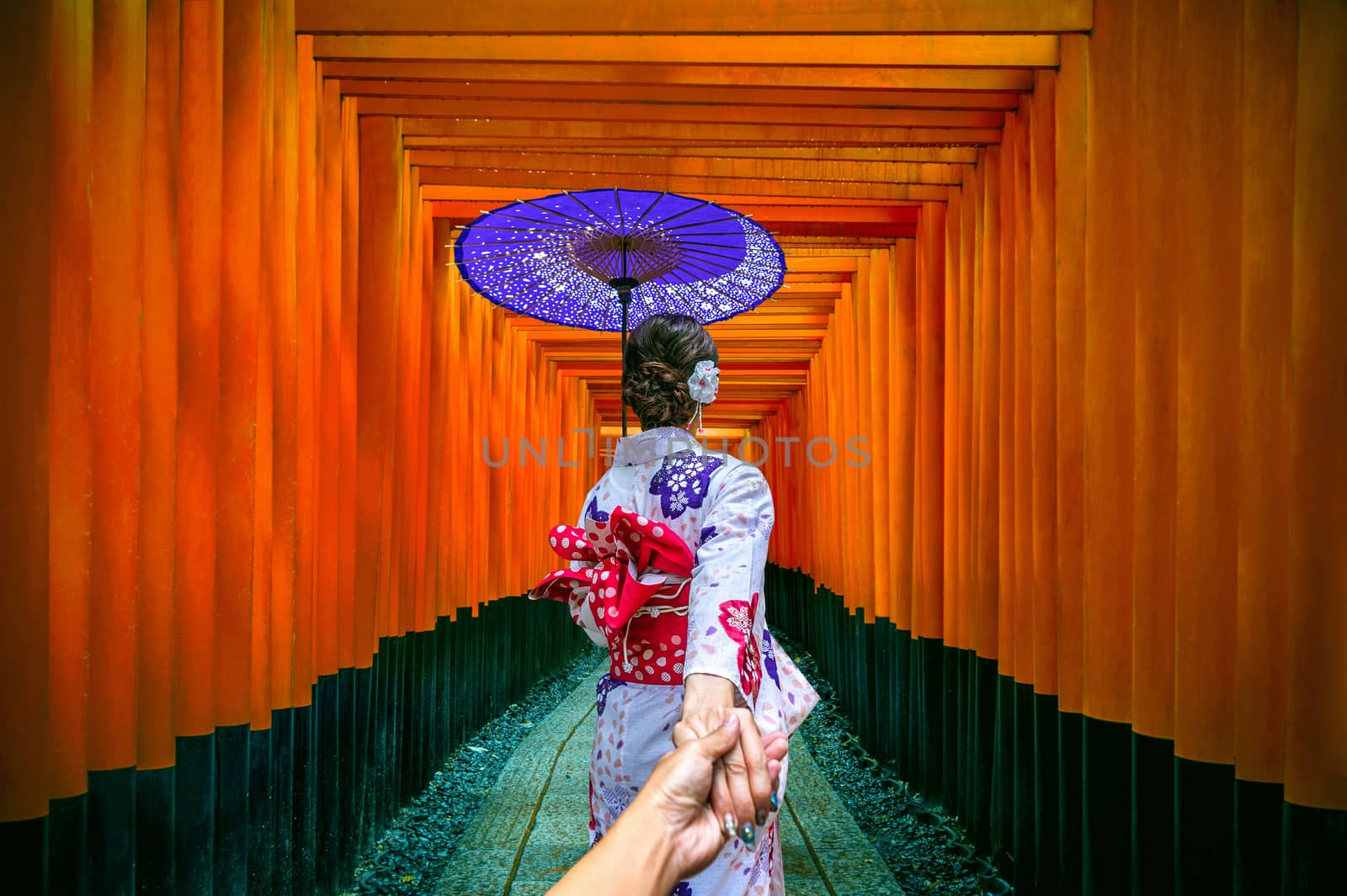 woman wearing japanese traditional kimono holding man's hand and leading him to gates walkway at fushimi inari taisha shrine in Kyoto, Japan. by gutarphotoghaphy