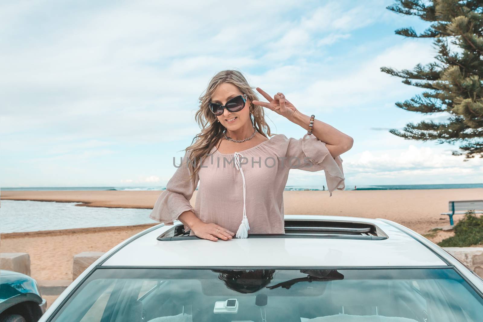 Fun carefree woman enjoy travel trip to beach in her car by lovleah