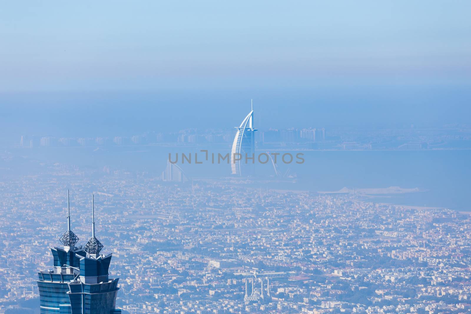 Skyline of Dubai beachfront with Burj Al Arab hotel on Jumeirah beach seen from Burj Khalifa viewpoint. Modern architecture, luxury beach resort, summer vacation and tourism concept.