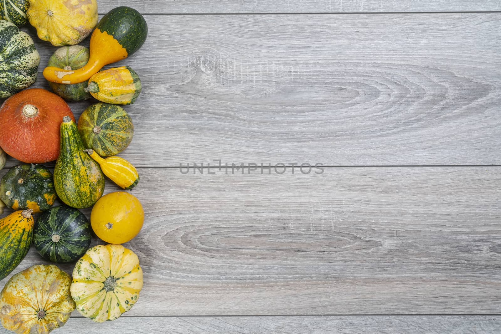 Some small pumpkins on a wooden table in the autumn