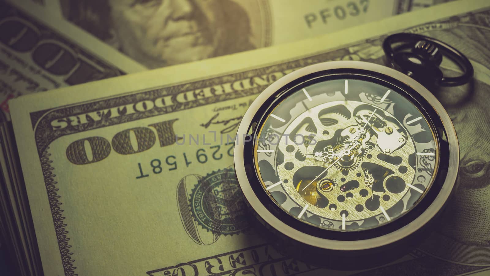 Pocket watch and dollar banknote stacking in darkness background. Concept of Time is money or Business.