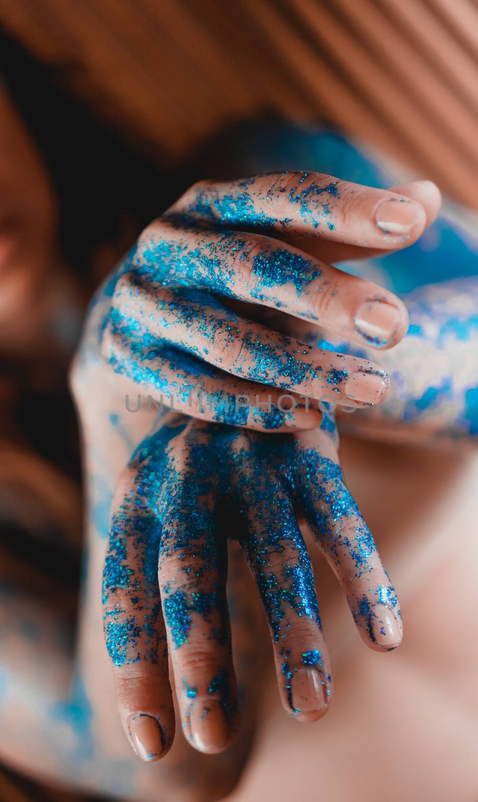 Blue glitter on woman hands. Smooth movements of the hands. Femininity and beauty