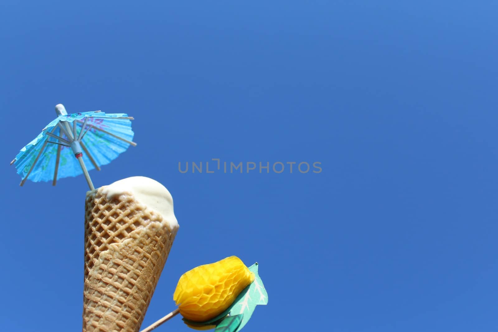 The picture shows an ice cream cone in front of the blue sky.