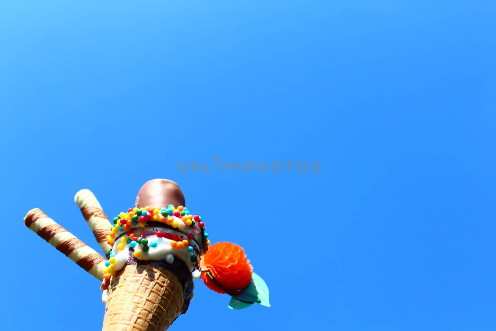 The picture shows an ice cream cone in front of the blue sky.