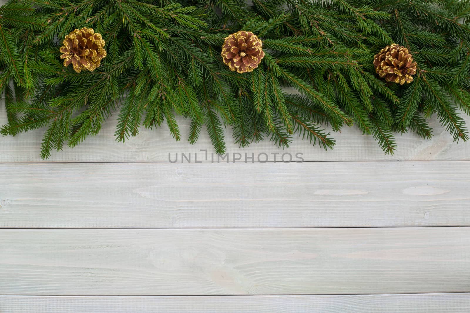 Christmas background with fir branches and cones on white toned natural wooden plank background texture provence style for copy space for text