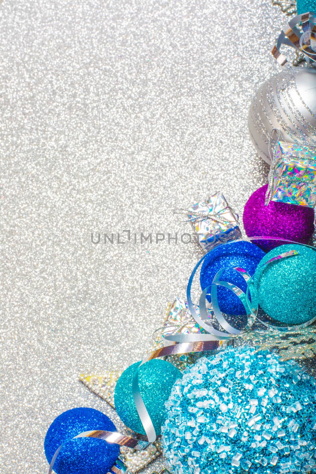 Christmas decoration of colorful glitter balls on silver glitter background with copy space for text new year card concept