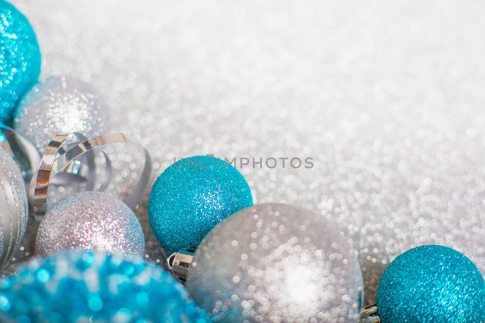 Christmas decoration of colorful glitter balls on silver glitter background with copy space for text new year card concept