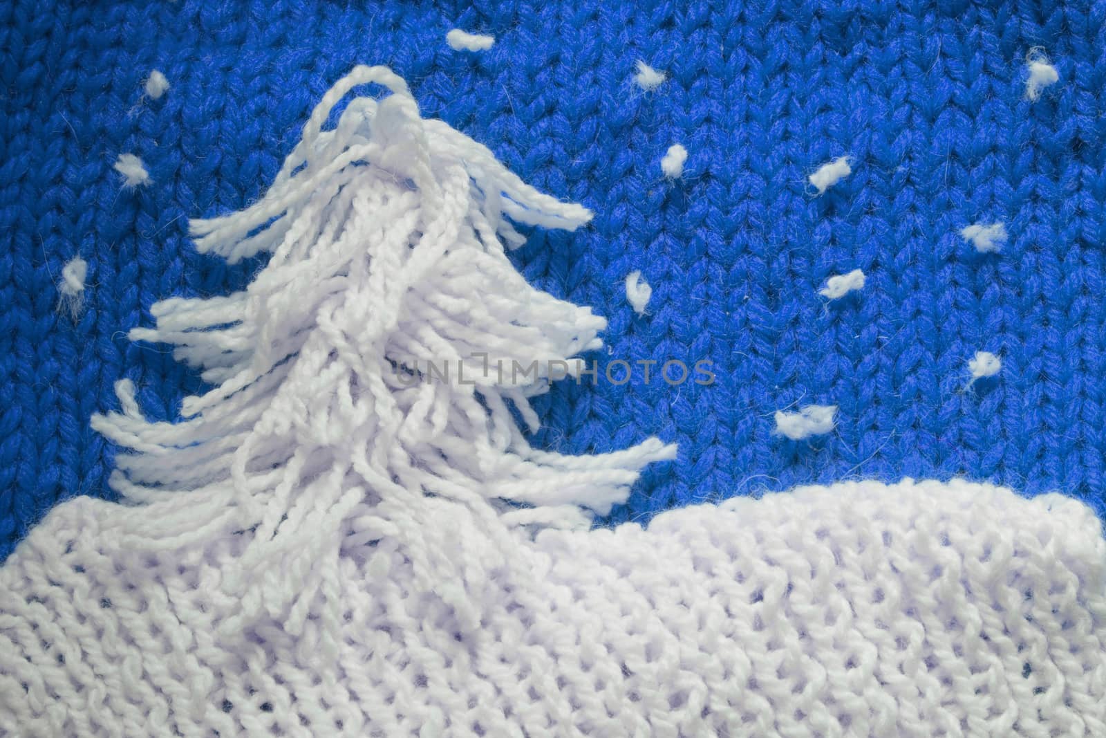 Hadmade Christmas tree on blue knitted woolen background with copy space for text Christmas concept