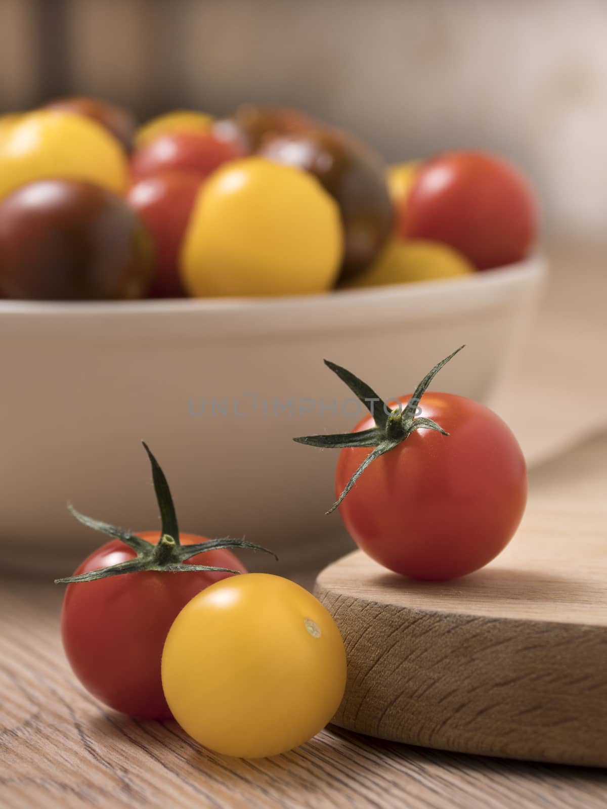 Cherry tomatoes, red,yellow and kamato on a wooden table.