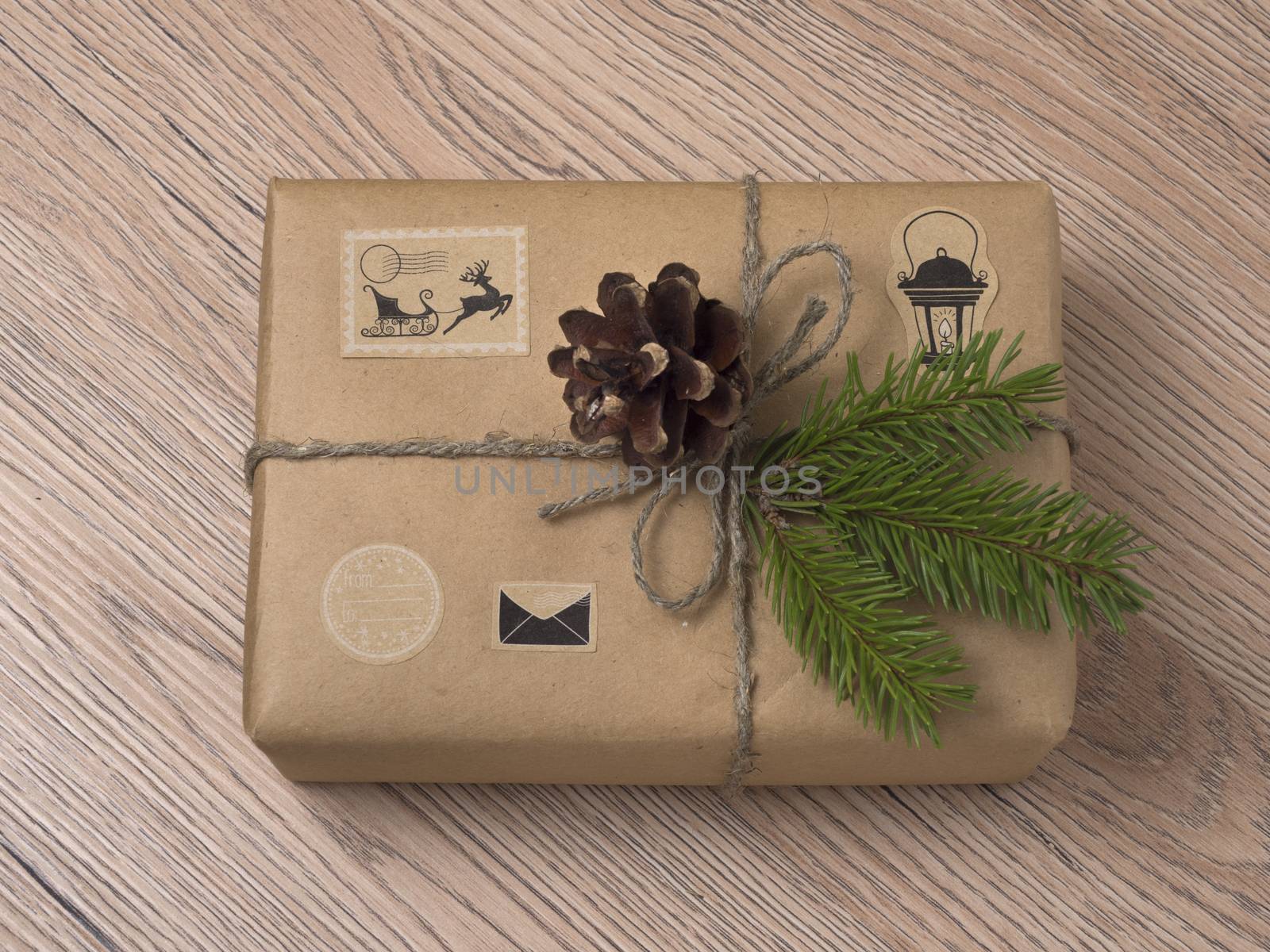 Christmas or New Year gift boxes wrapped in kraft paper with fir branch on wooden background.