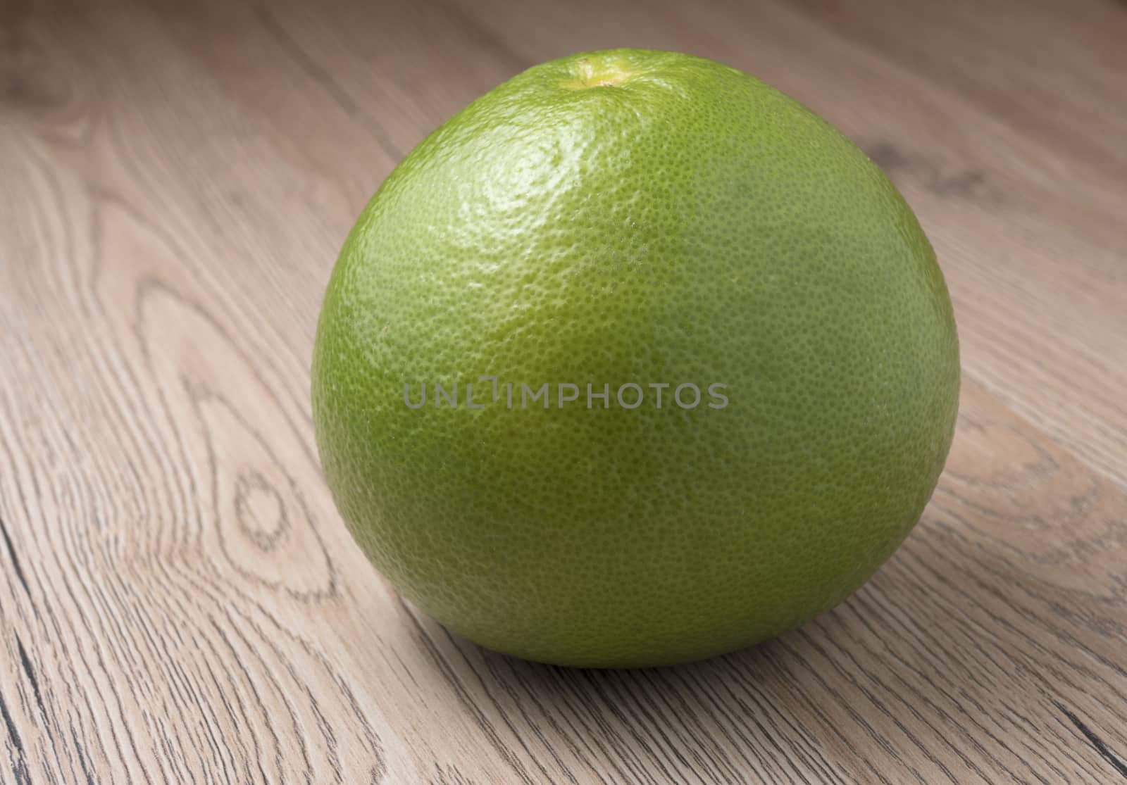 Whole Green Sweetie on wooden background. Close up view.