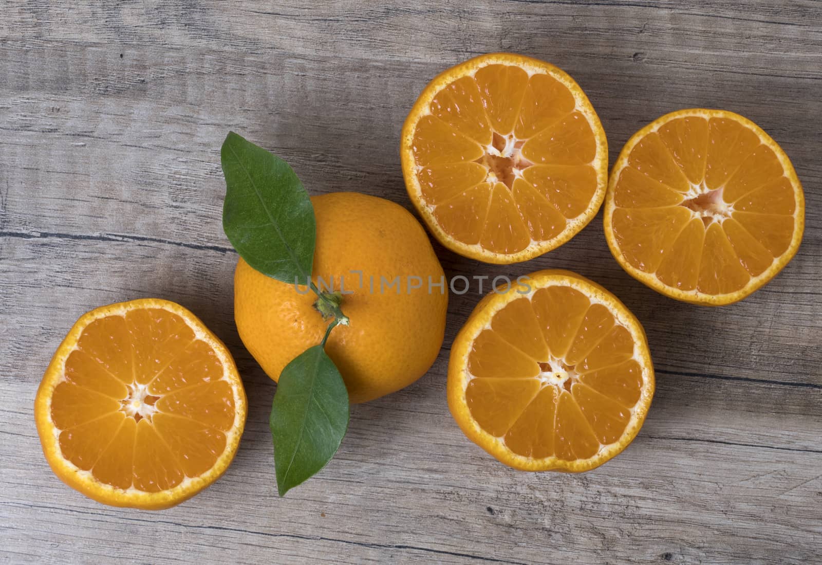 Fresh ripe tangerines with leaves on a wooden background. Top view.