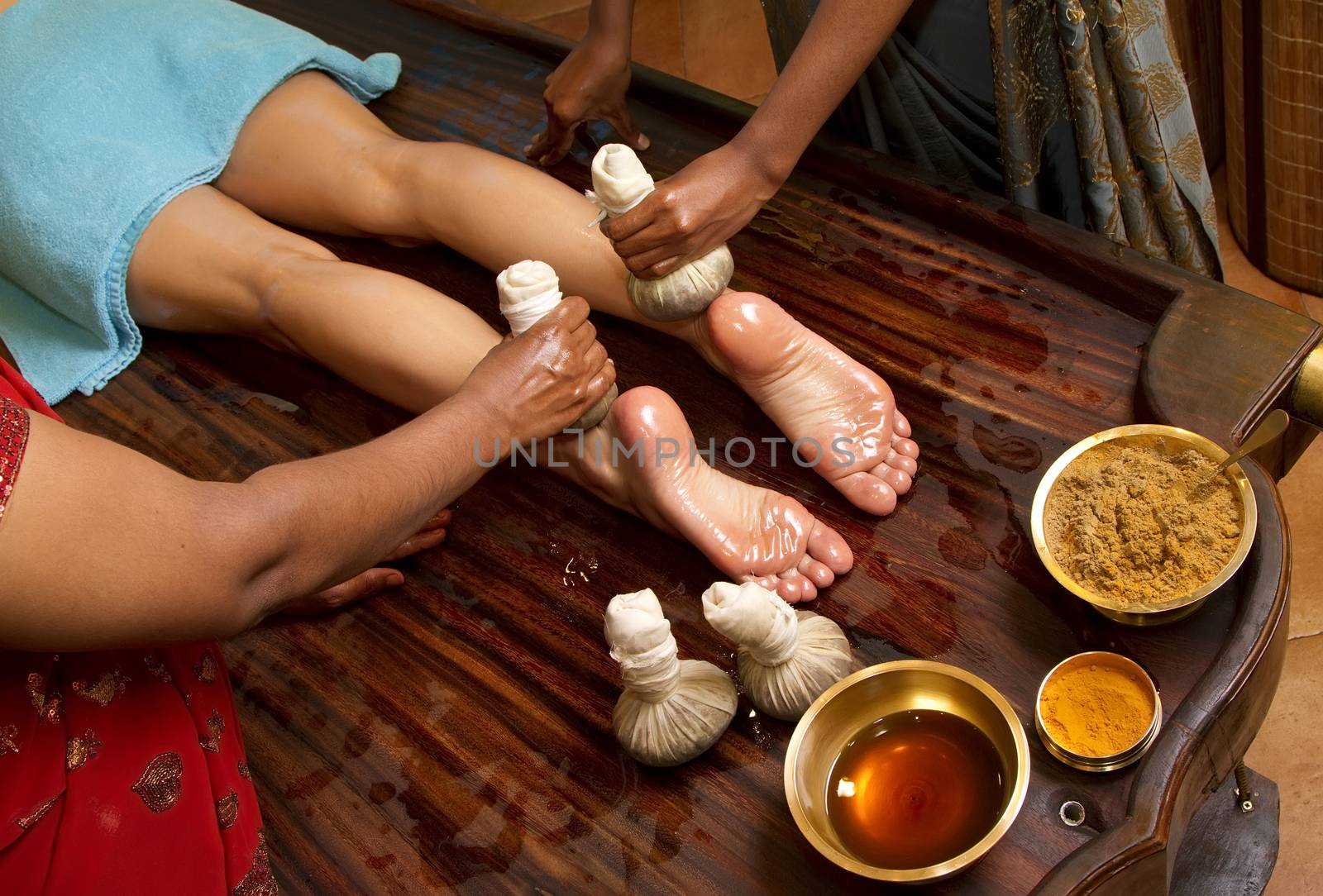   indian doctors doing traditional ayurvedic oil foot massage