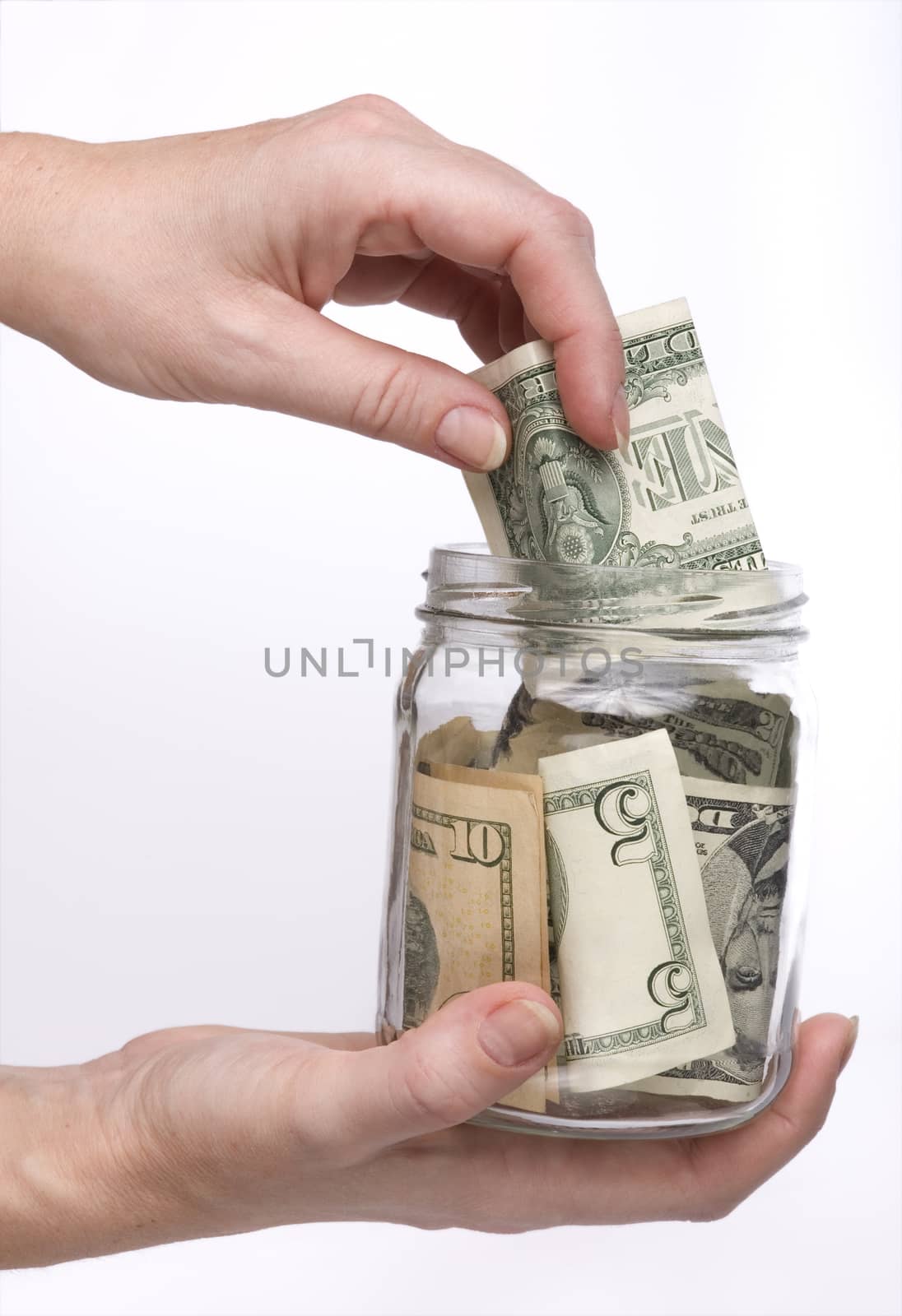 putting money in the glass jar for storage