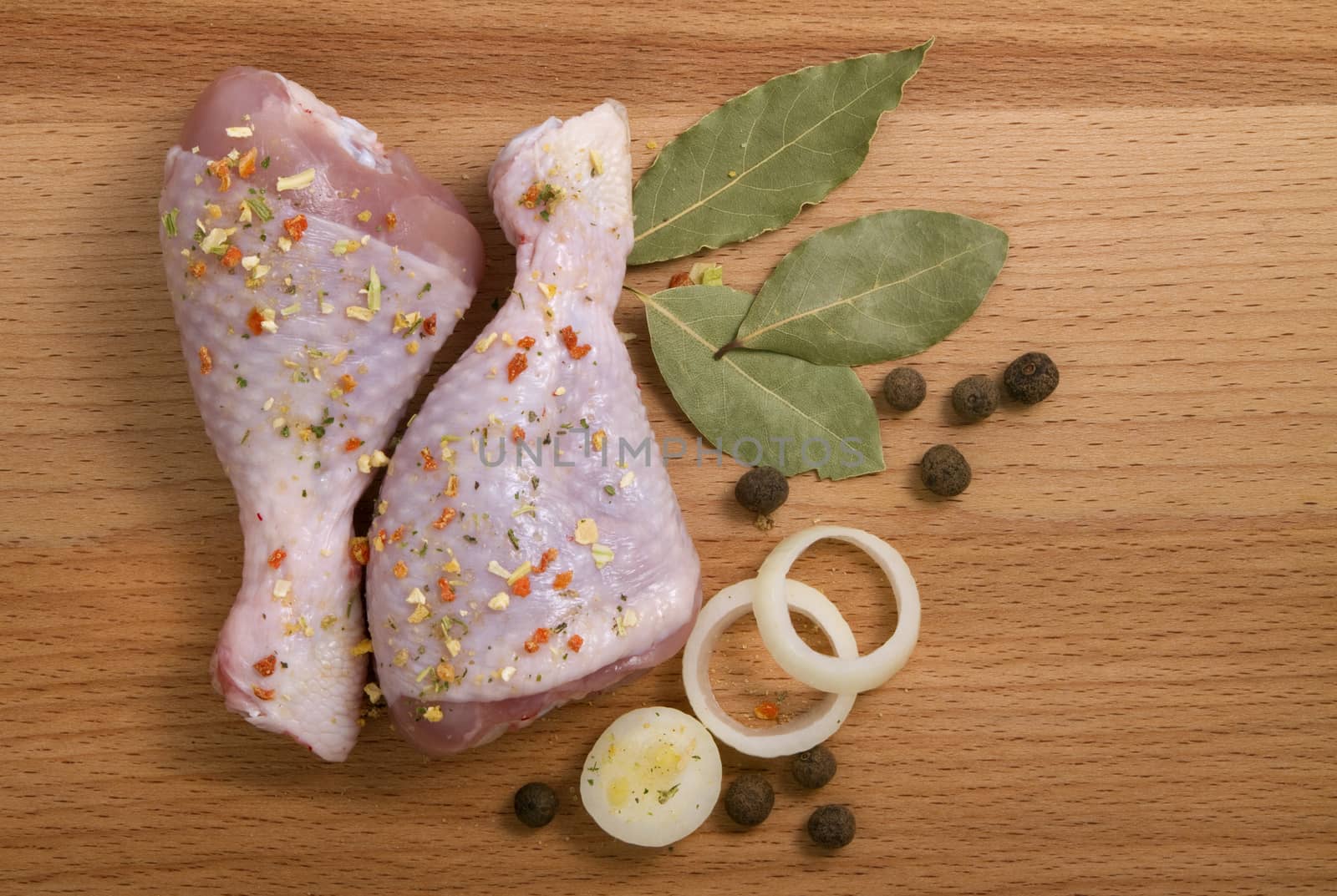 raw chicken meat with herbs, onions and peppers, on a cutting board