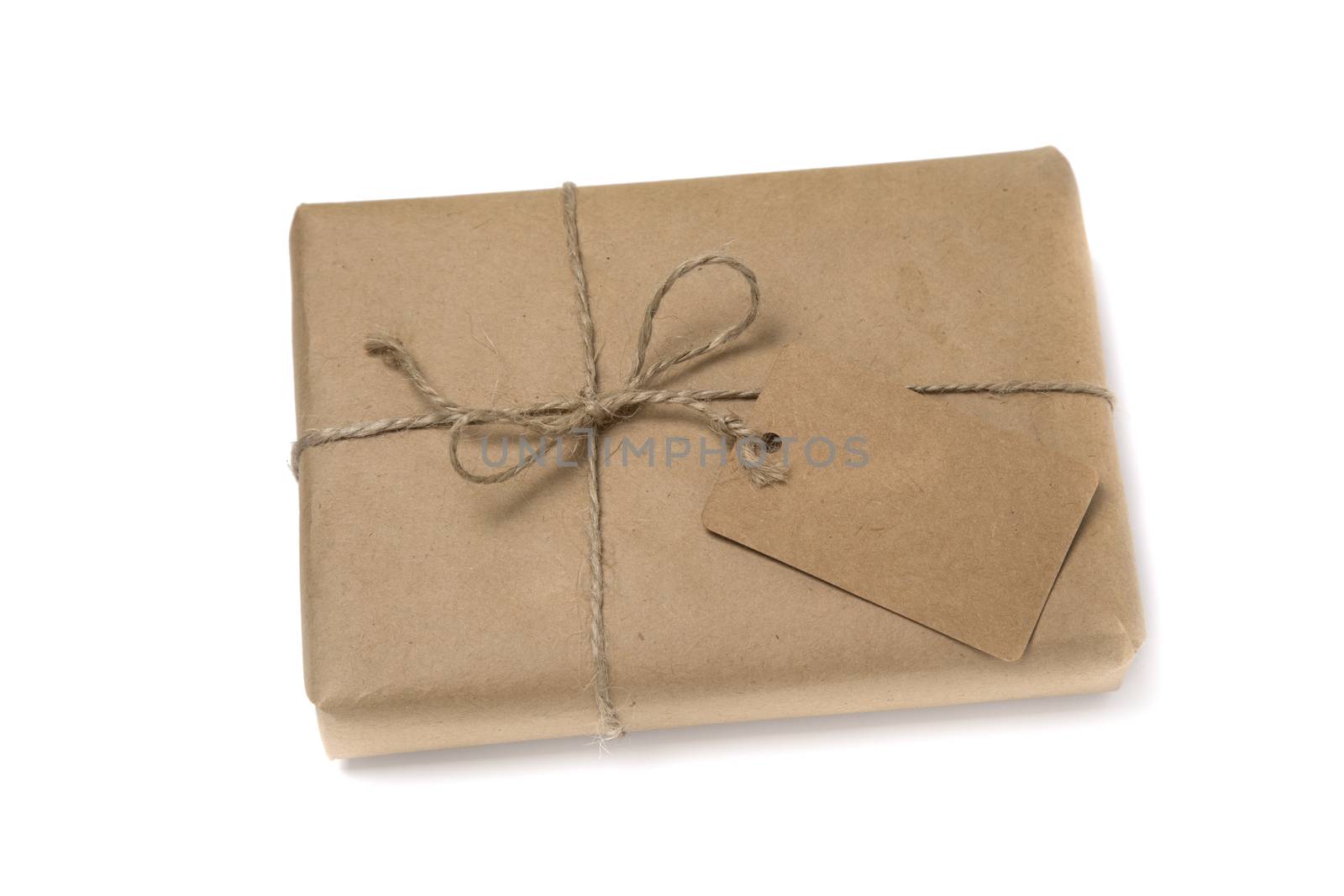 Christmas or New Year gift box wrapped in kraft paper with blank gift tag isolated on white background