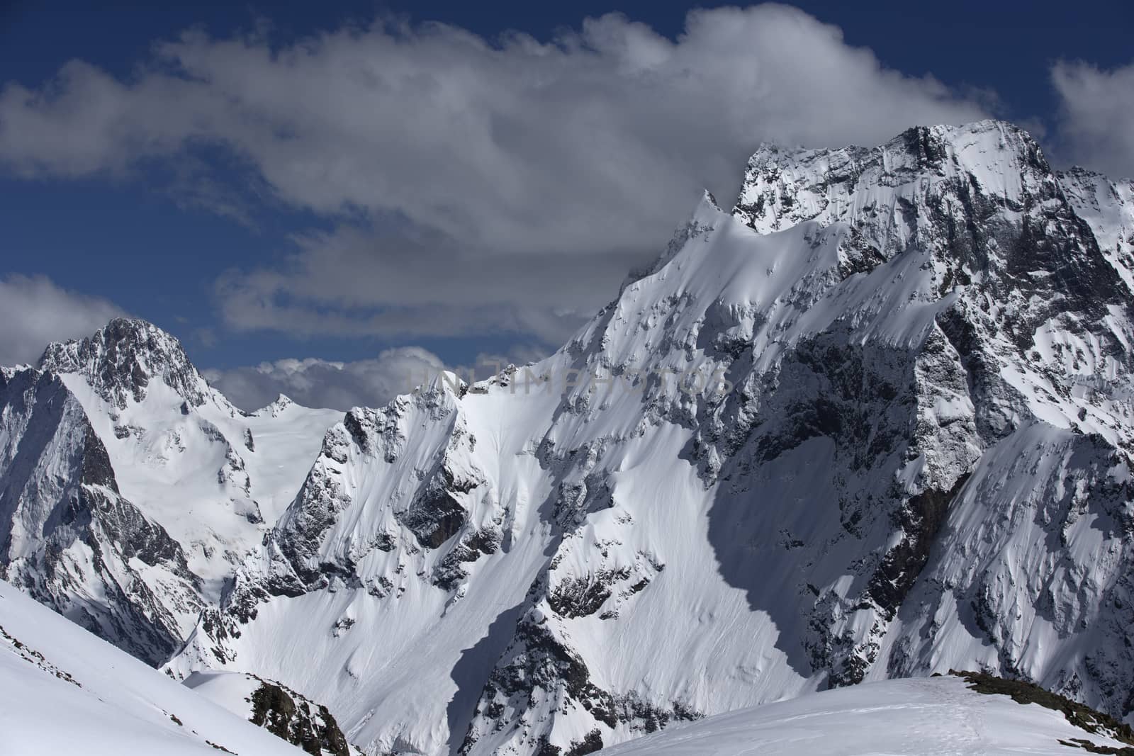 View of Snow Mountain Range Landscape with Blue Sky. Russia, Caucasus.