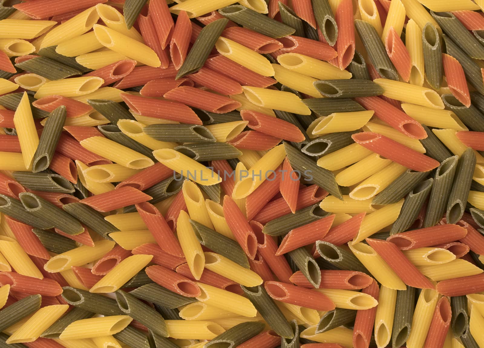Tri-color penne pasta. Tomato, spinach and wheat pastas. Top view.