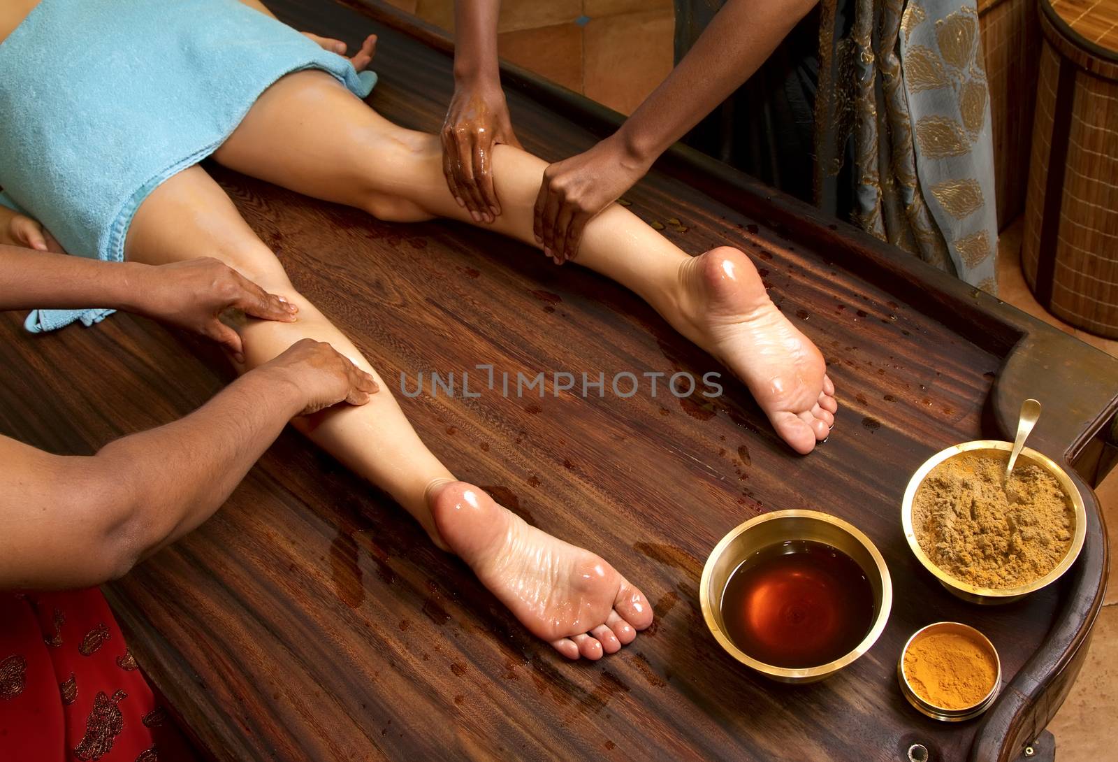   indian doctors doing traditional ayurvedic oil foot massage