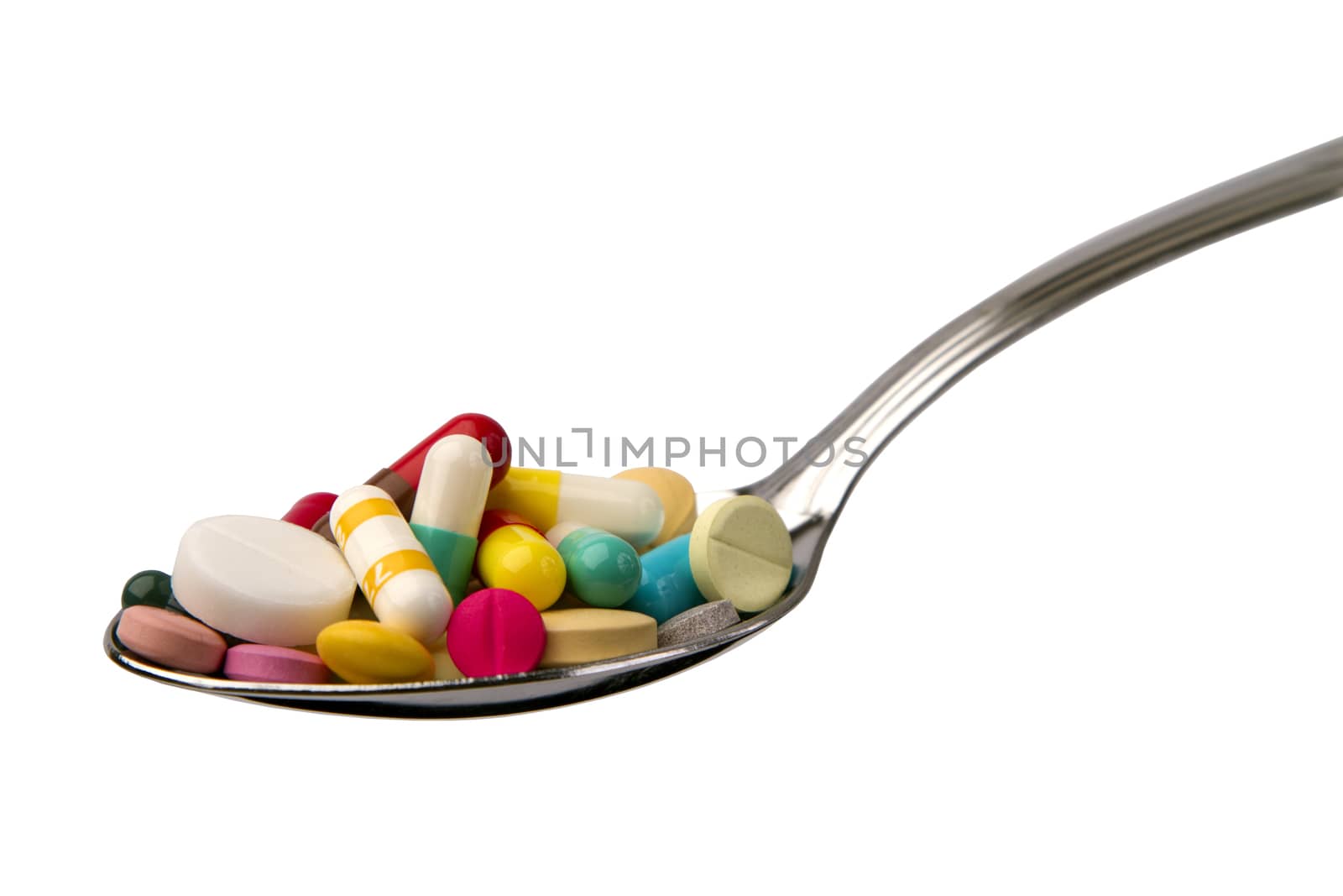 spoon full of tablets isolated on white background