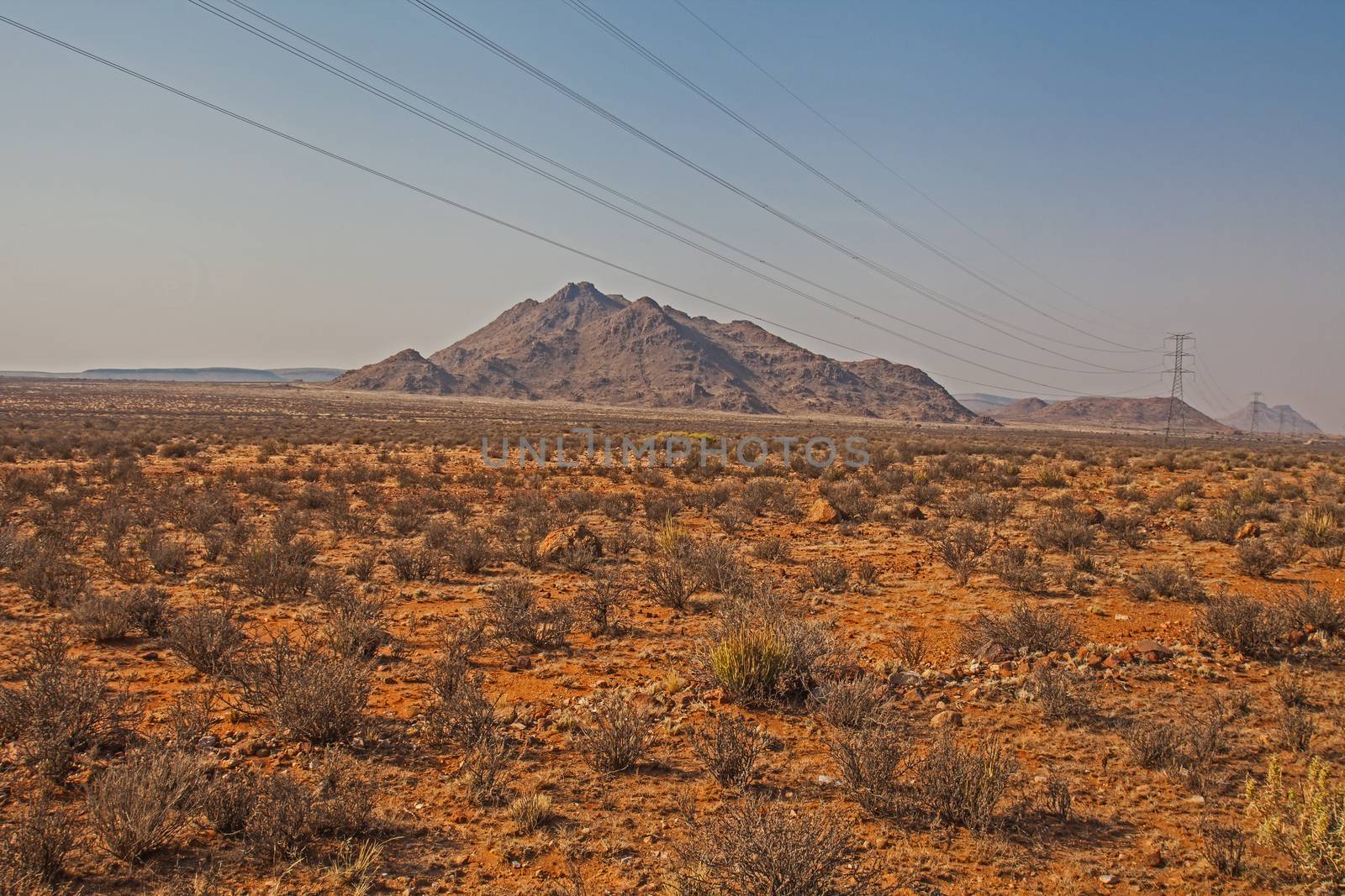 High voltage power lines in the lonely Kalahari desert indicating life and industry in this barren landscape.