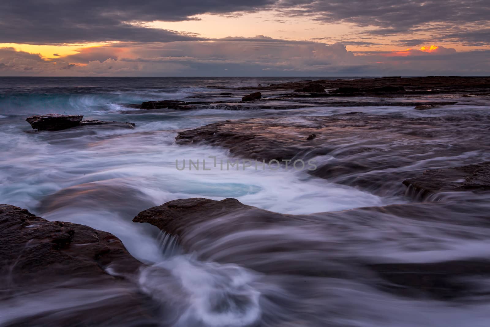 Early morning sunrise views from the edge of the rocky coastline of Coalcliff in the  Illawarra region Australia