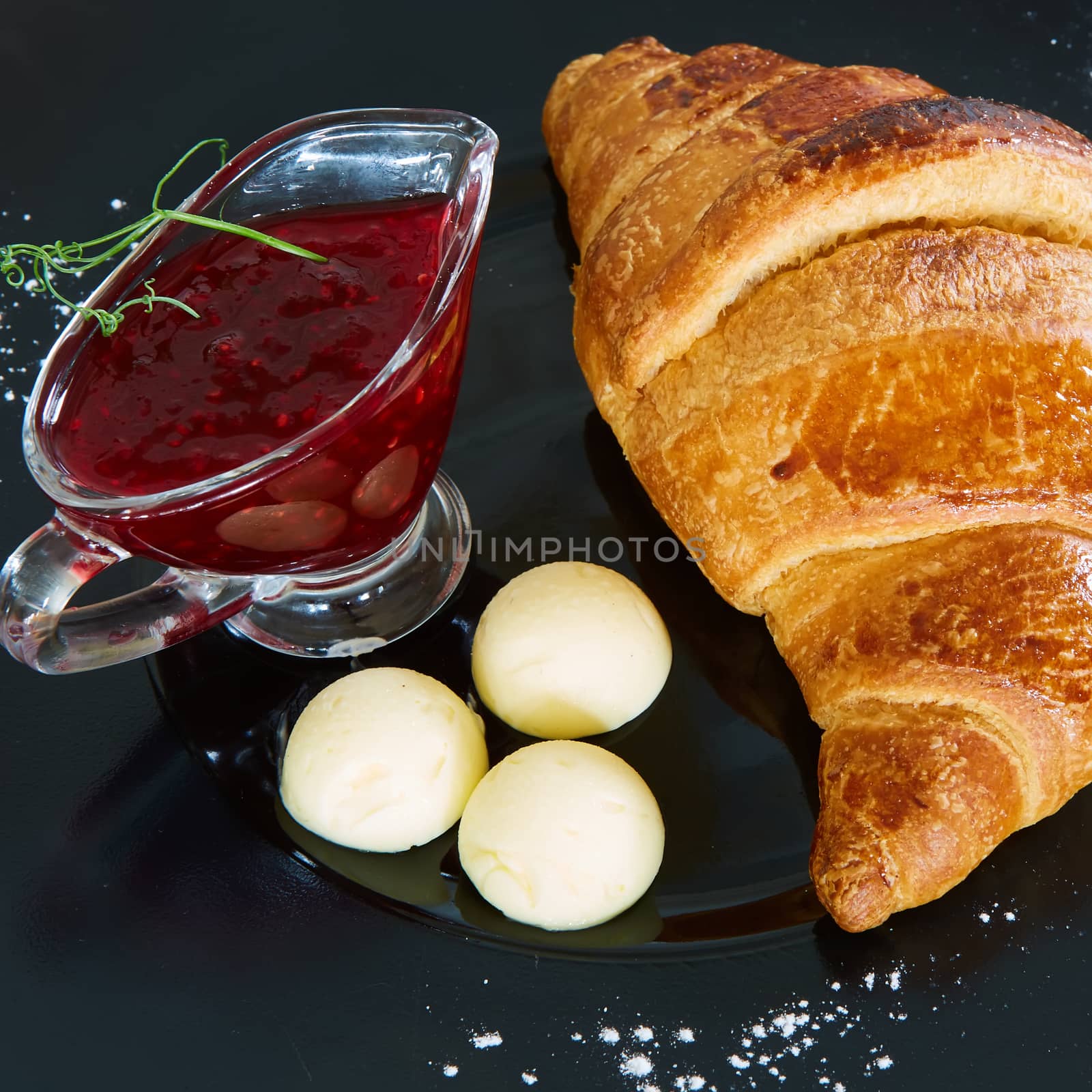 Closeup of butter, jam and fresh croissants by sarymsakov