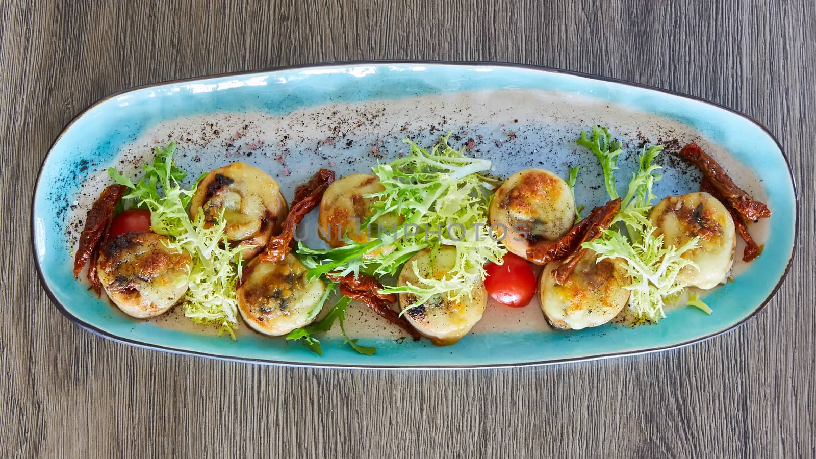 Fried scallops with butter lemon spicy sauce served with green salad. Top view, copy space. by sarymsakov