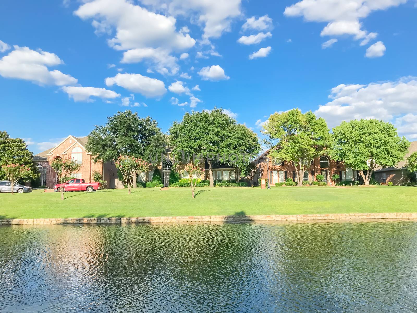 Beautiful riverside residential neighborhood in suburbs Dallas under blue cloud sky by trongnguyen