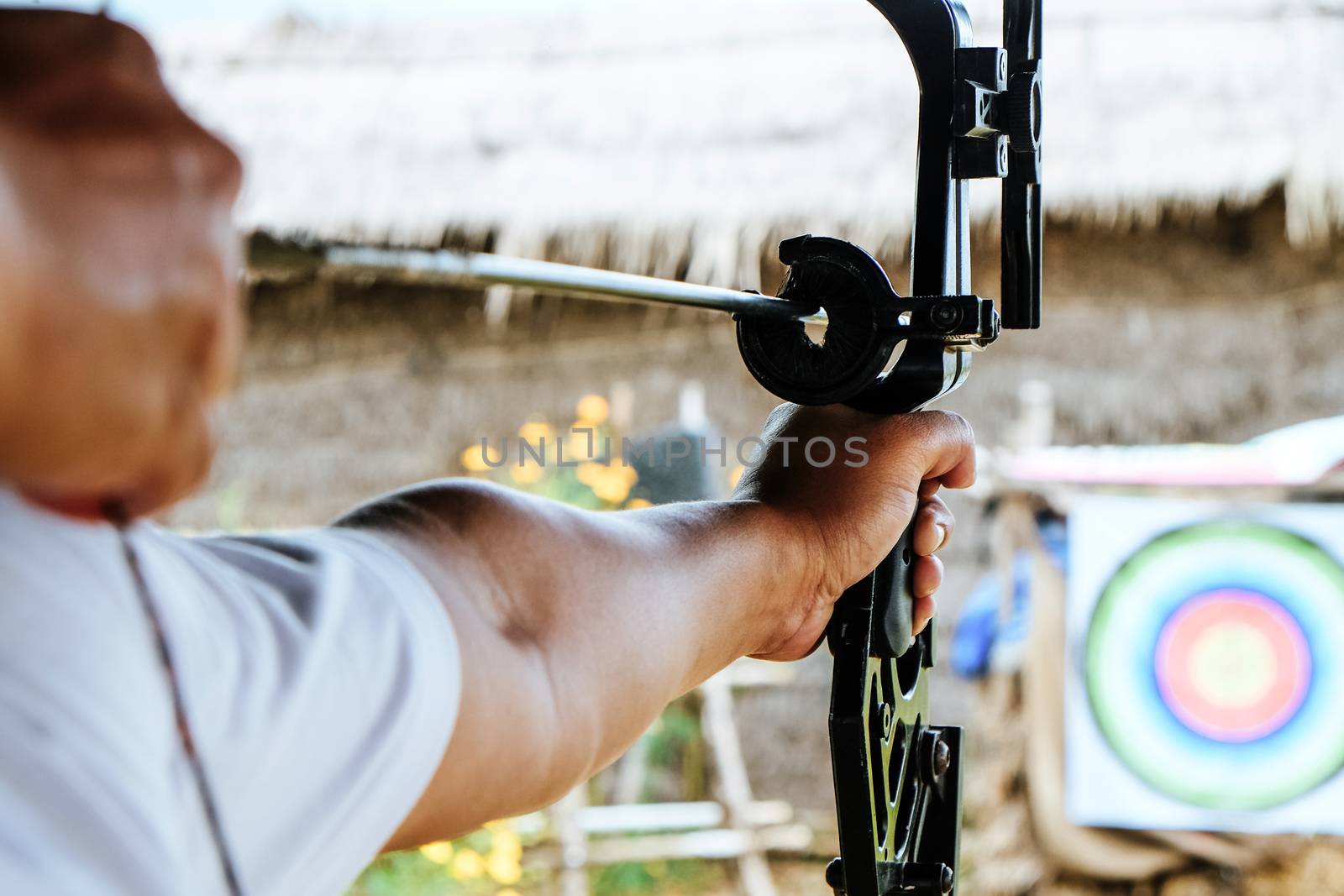 Archer holds his bow aiming at a target