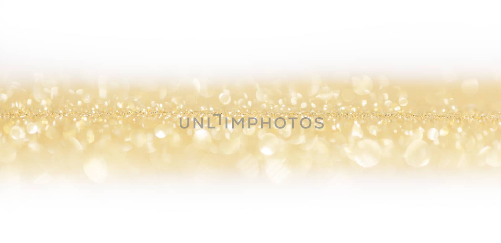 Golden festive glitter background with defocused lights , white copy space