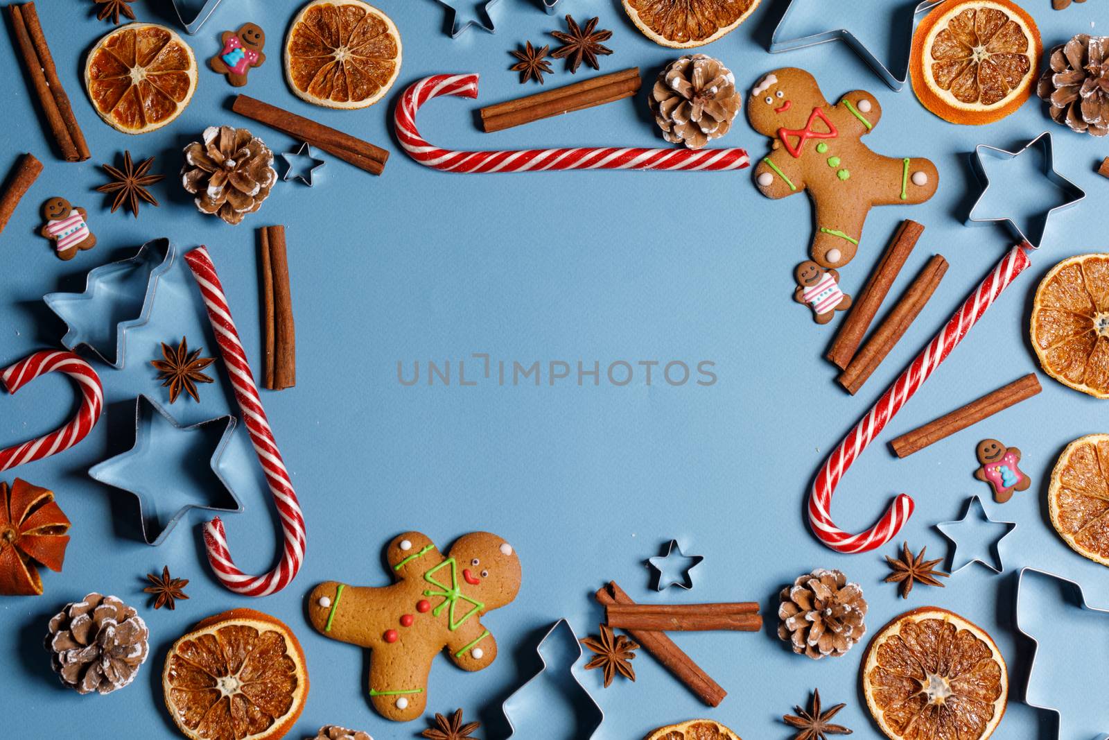 Christmas food frame. Gingerbread cookies, spices and decorations on blue background with copy space