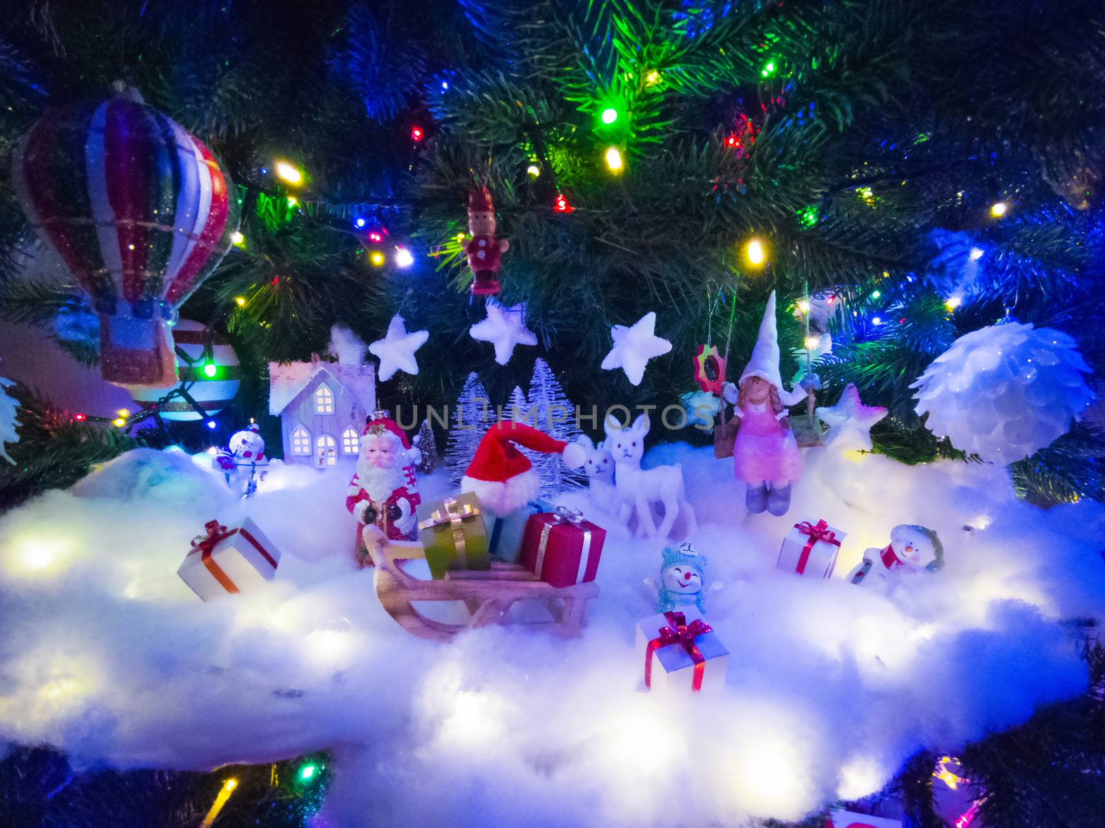 Beautiful glowing christmas tree with many present boxes and decor on snow