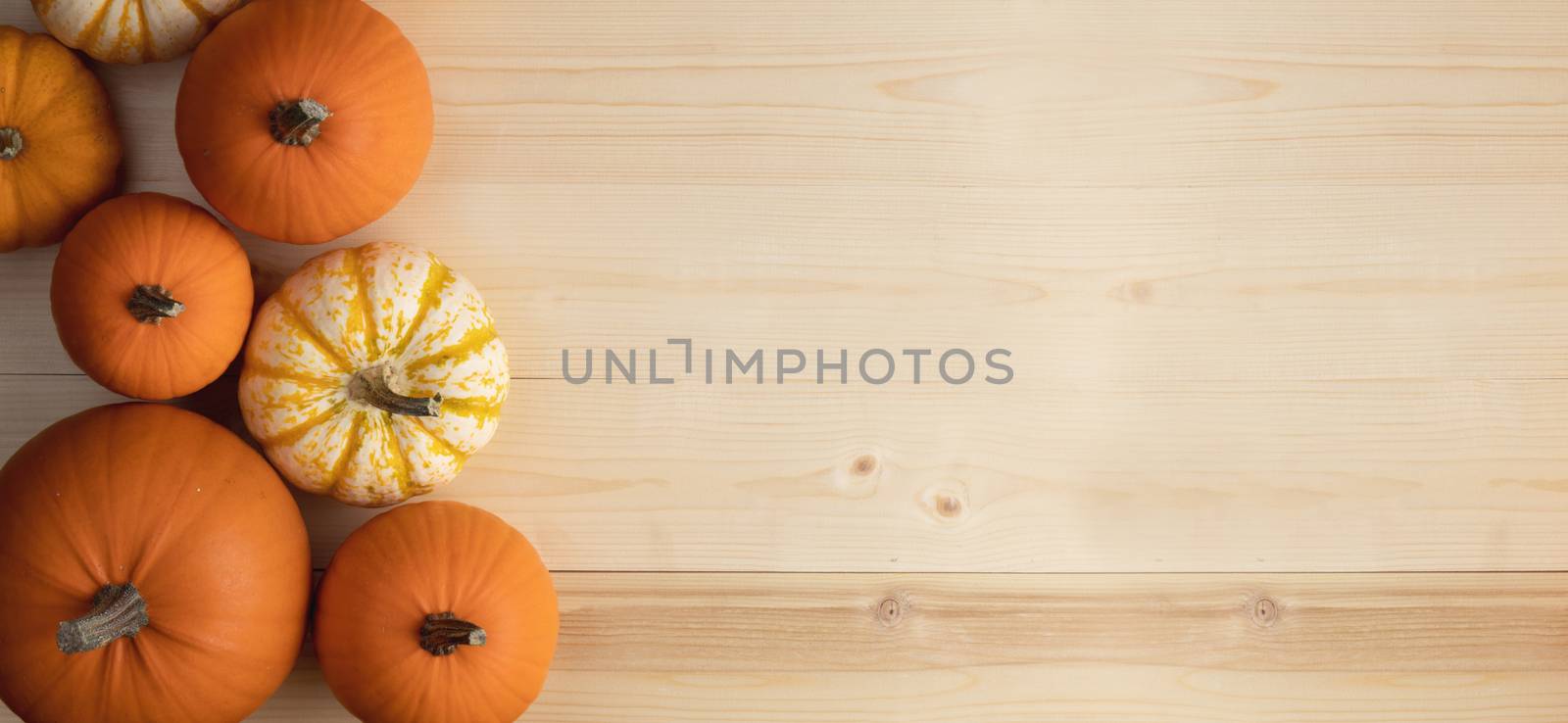 Many orange pumpkins on light wooden background, Halloween concept, top view with copy space