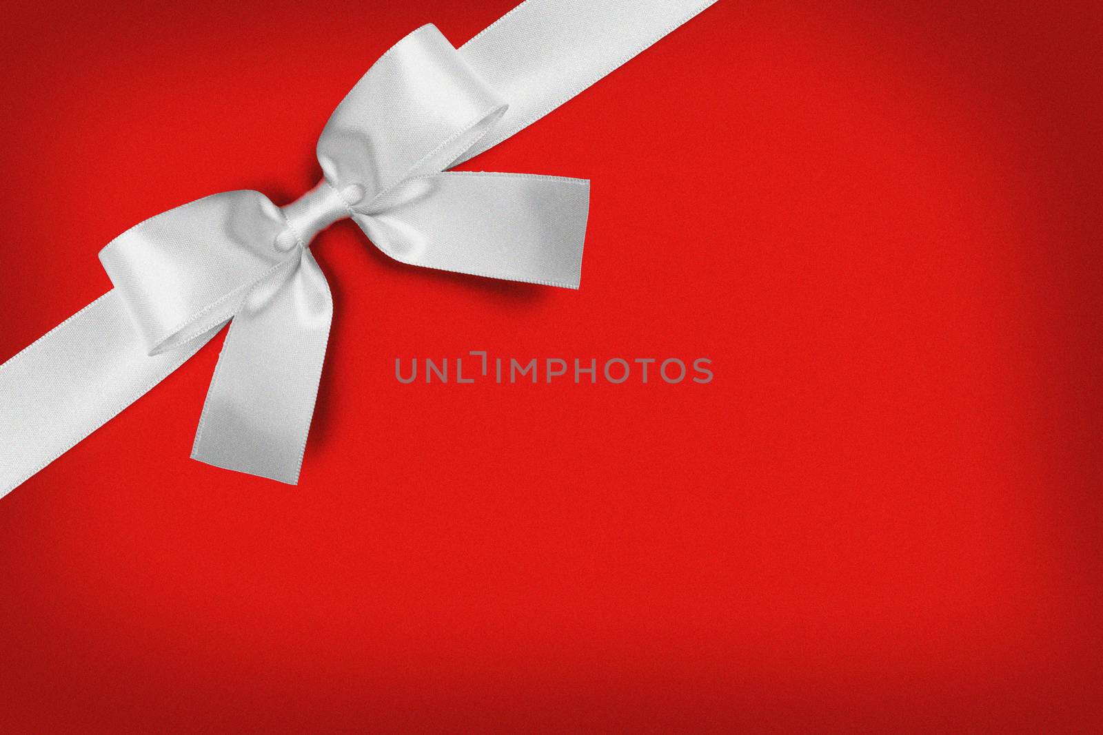White gift bow on red background copy space for text