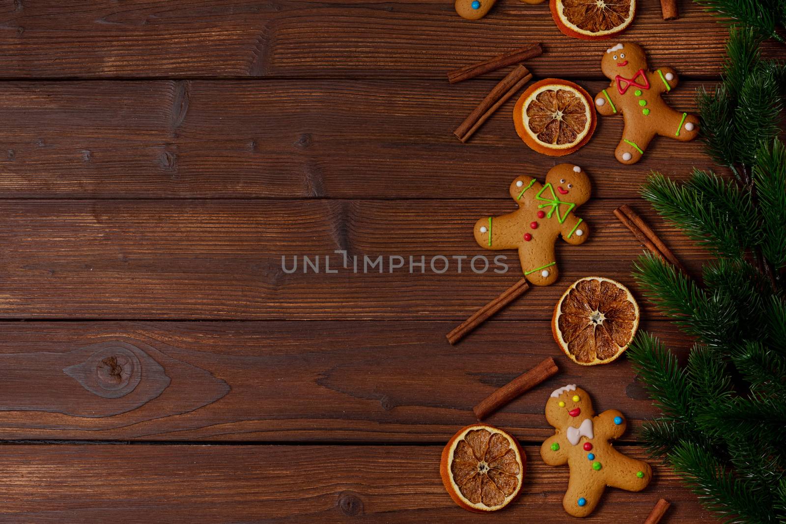 Christmas food frame. Gingerbread cookies, spices and fir branches on wooden background with copy space