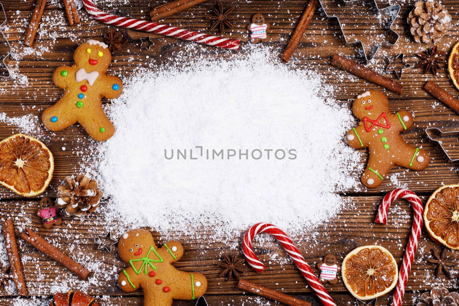 Christmas food frame. Gingerbread cookies, spices and decorations on wooden background with copy space on snow