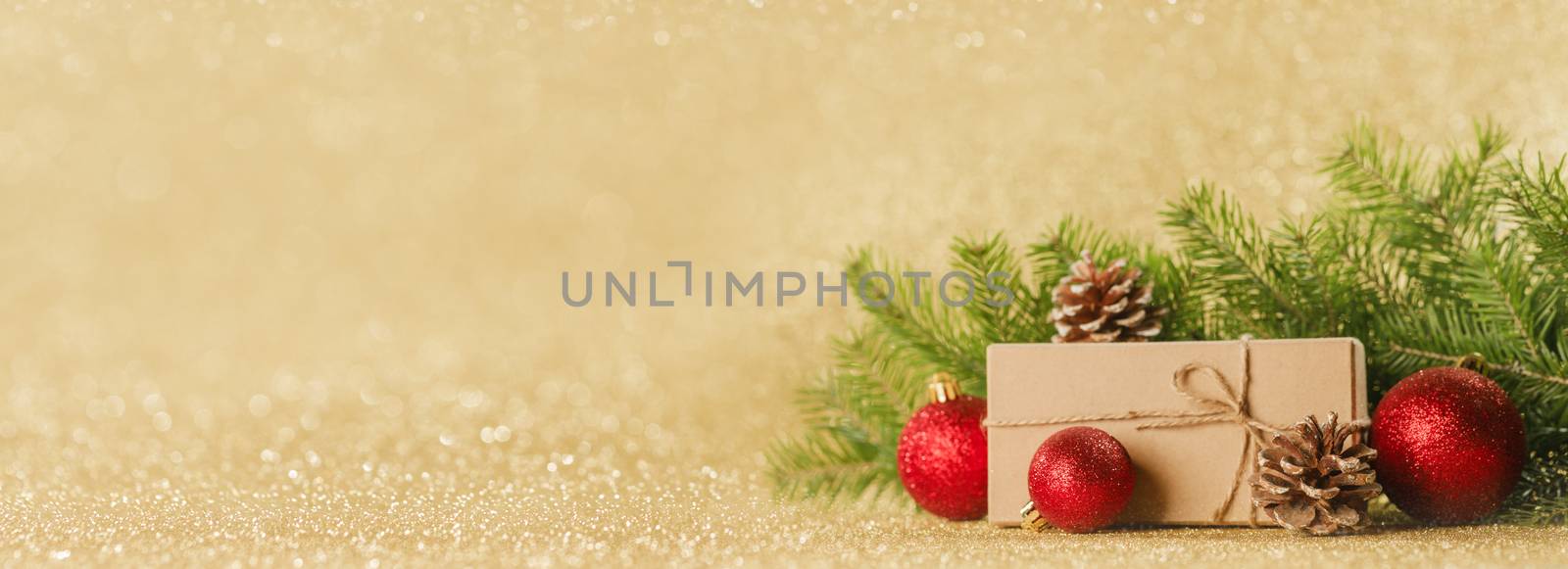 Christmas toys, decorations, present gift box wrapped in kraft paper on golden glitter background, copy space