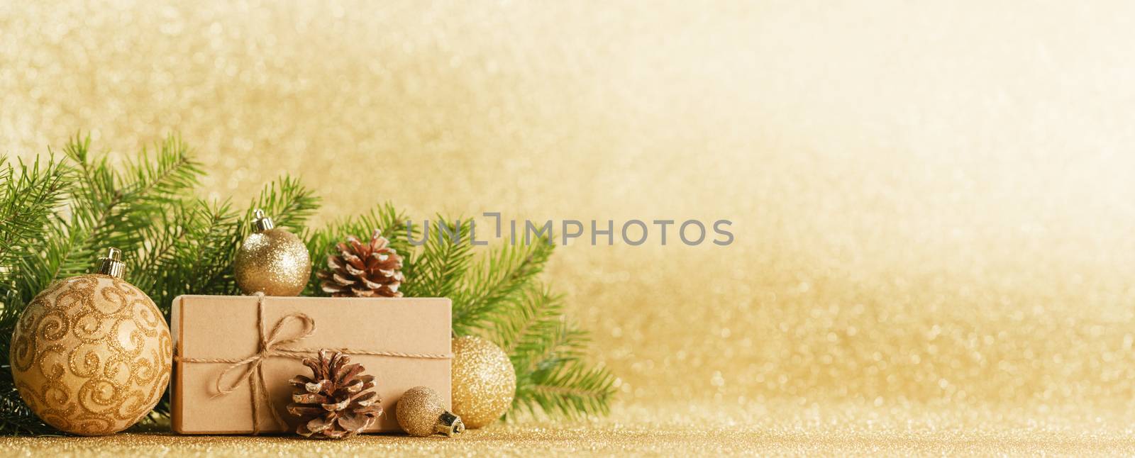 Christmas toys, decorations, present gift box wrapped in kraft paper on golden glitter background, copy space