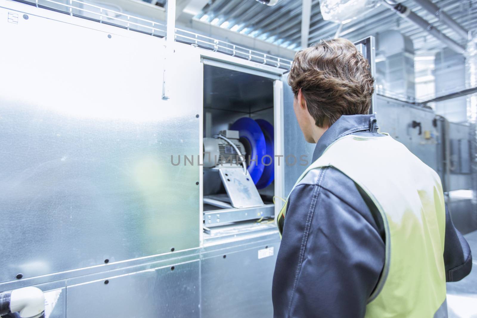 Worker in electrical switchgear room of CNC plant