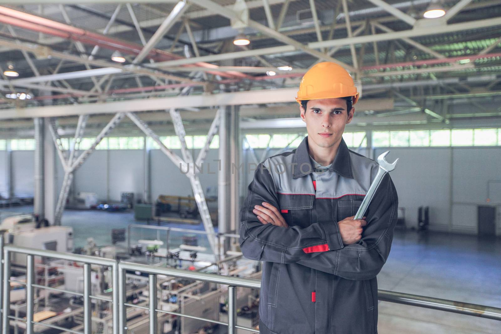 Portrait of young worker with wrench at CNC factory