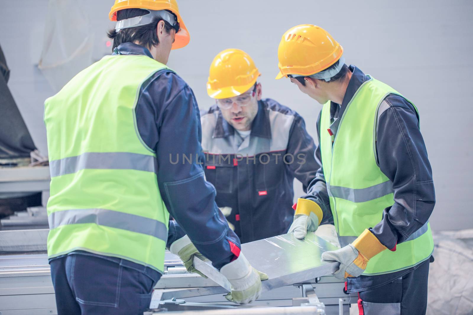 Workers taking aluminium billet at CNC machine shop