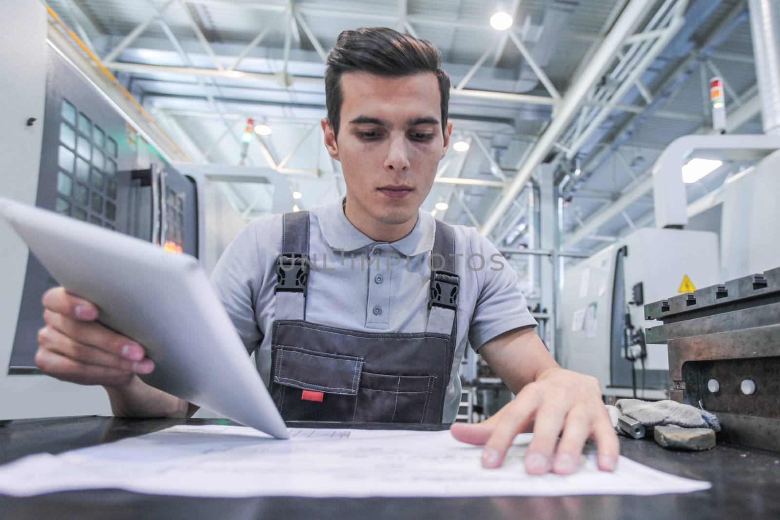 Man working with documents at plant near CNC machines