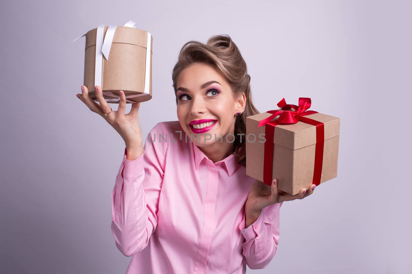 Young woman puts her ear to the presents with bows