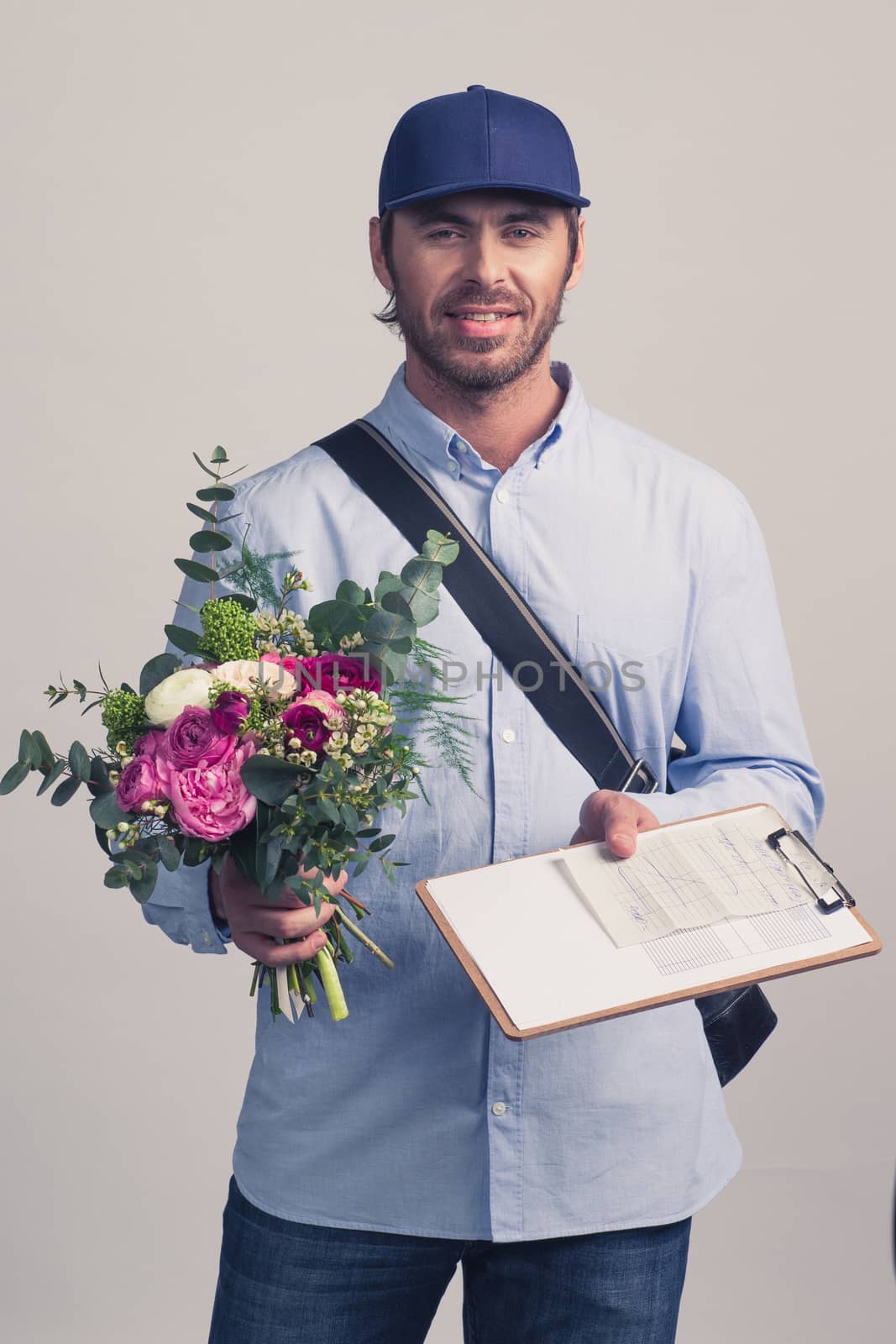 Delivery man holding flower bouquet and form