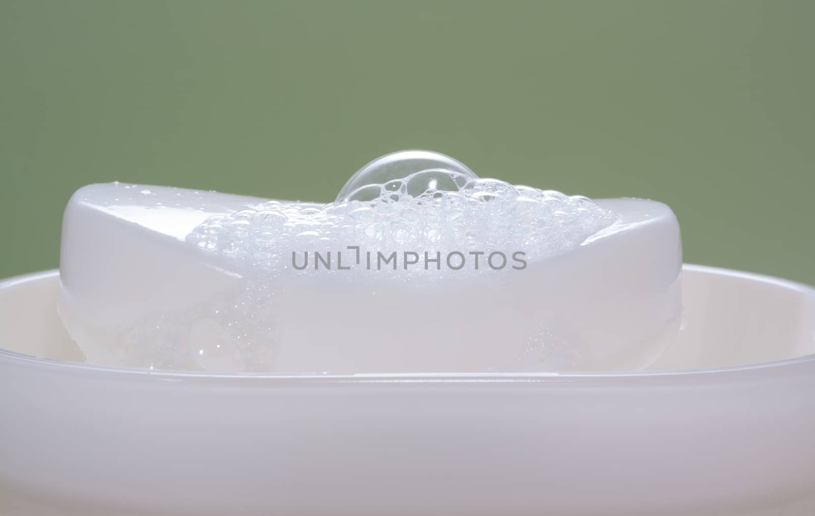white soap bar in a soap-holder by lanalanglois